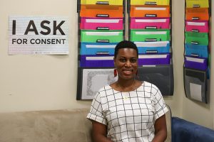 Ashley Slay in her office at SARP. Poster says "I ask for consent."