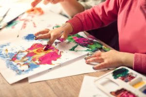 A photo of a young child finger painting.